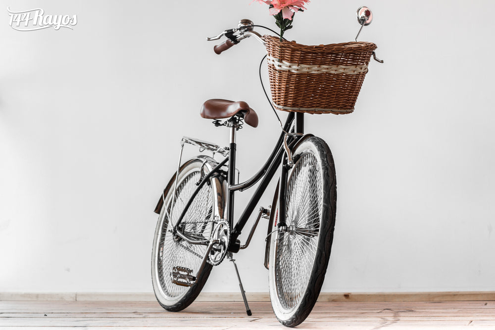 Vista frontal en ángulo de la bicicleta Cisne Negro Cromado 144 con canasta de mimbre y flores